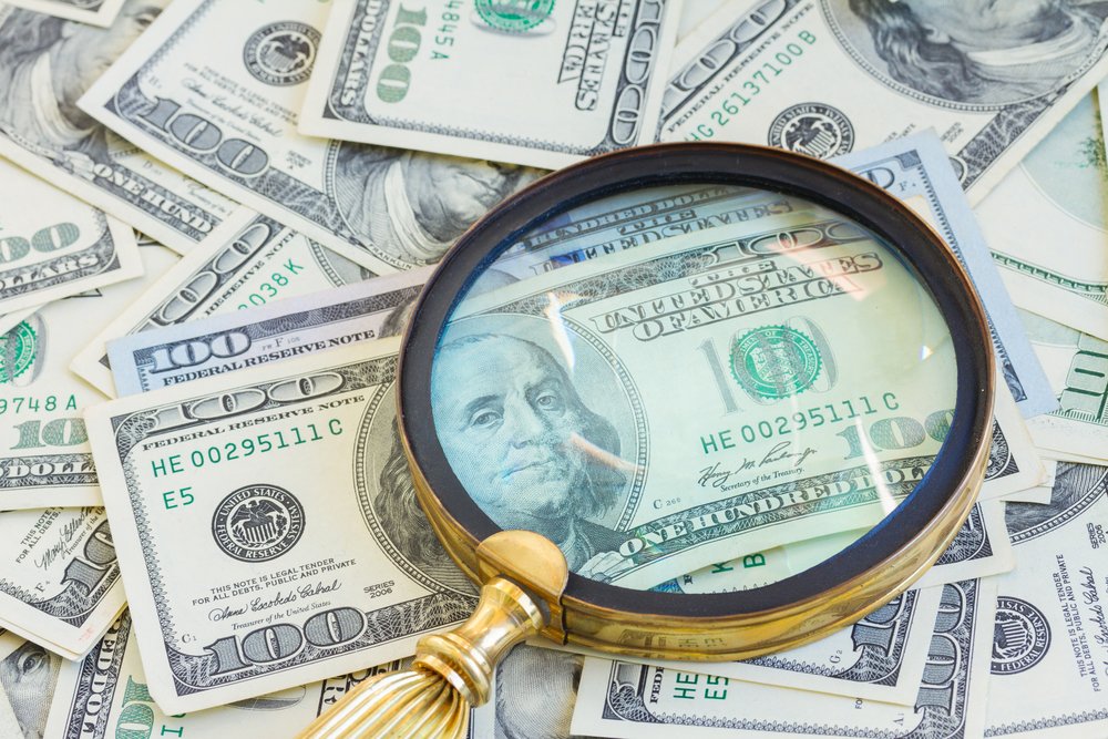 Pile,Of,American,Dollars,Money,Under,Manifying,Glass,Close,Up