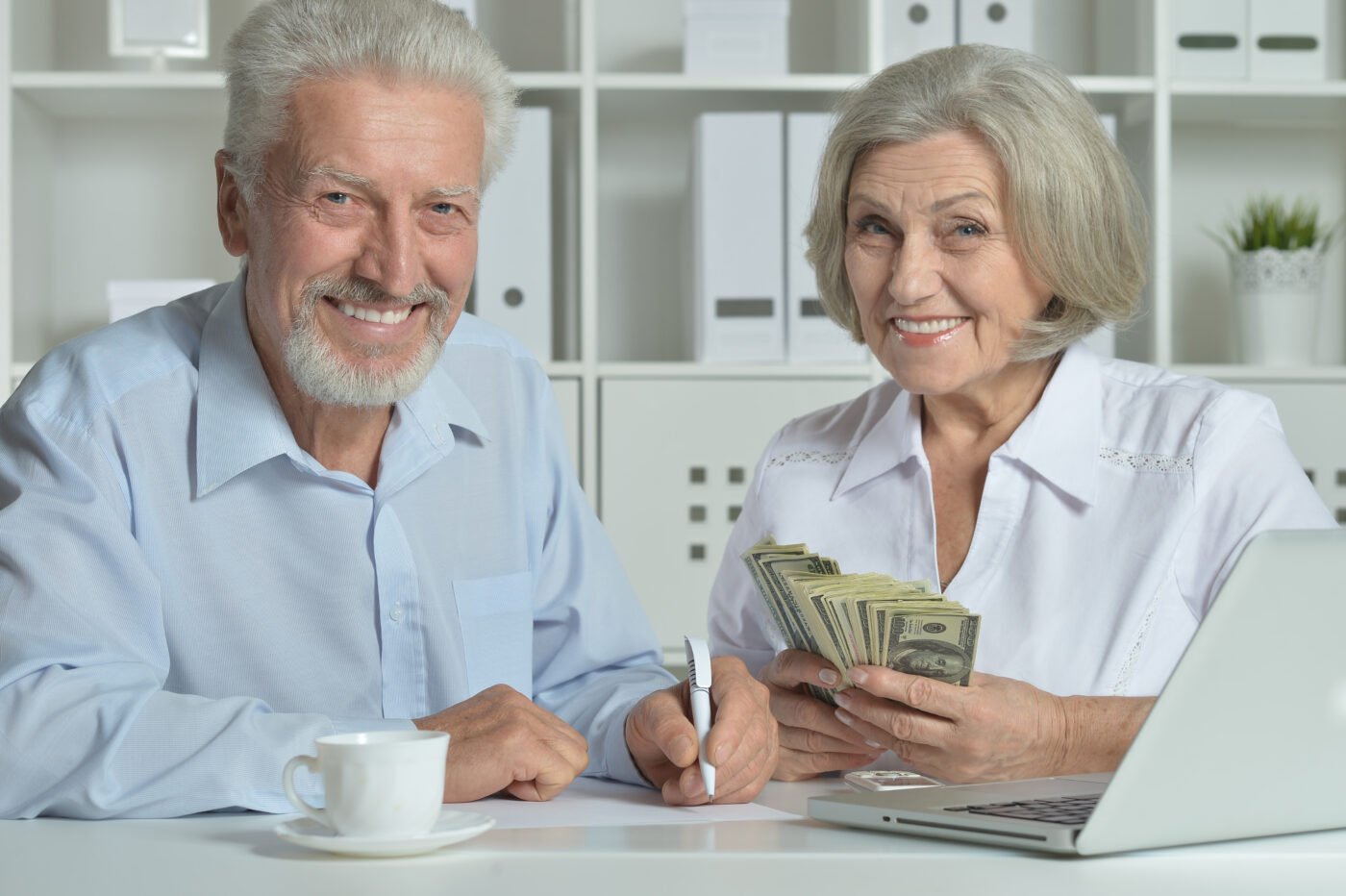 Happy,Senior,Couple,With,Laptop,And,Money,In,Office